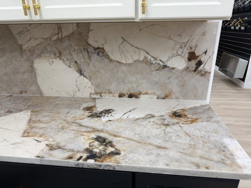 Countertop and matching backsplash in white stone with bold dark and rust-colored markings