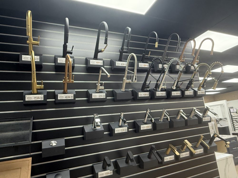 Wall display of faucets in gold, matte black, and chrome finishes