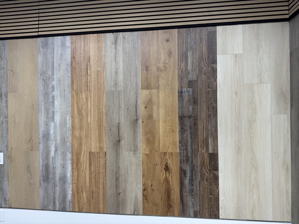 Grey and brown plank flooring samples on a display wall