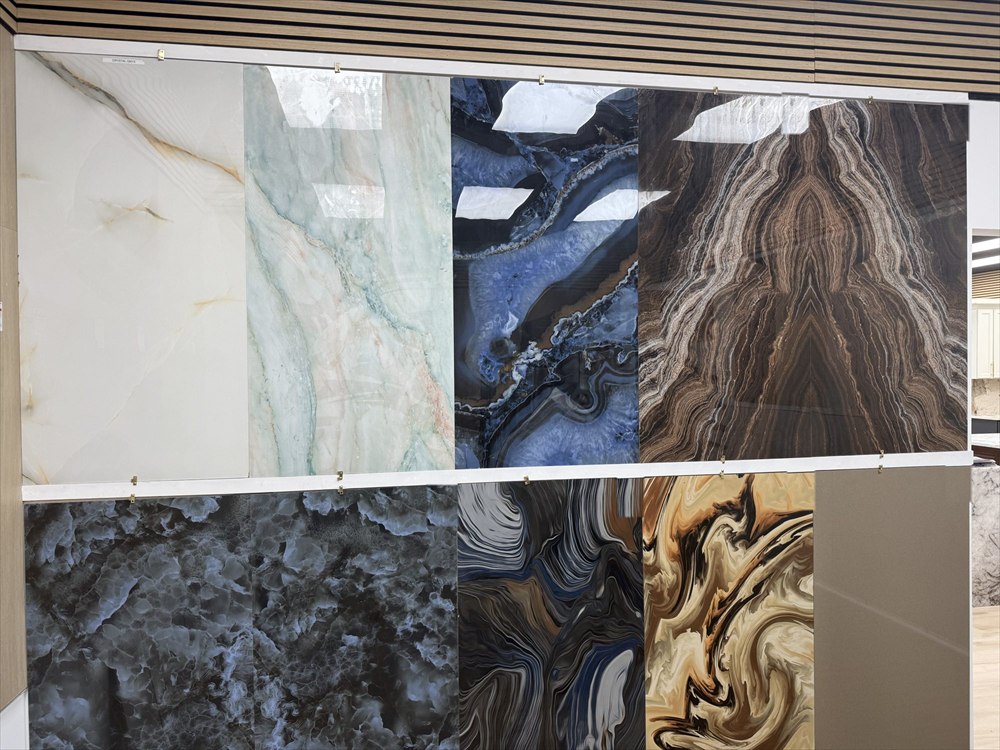 Polished porcelain tiles in onyx, blue agate, and swirled brown and gold patterns on a showroom display wall
