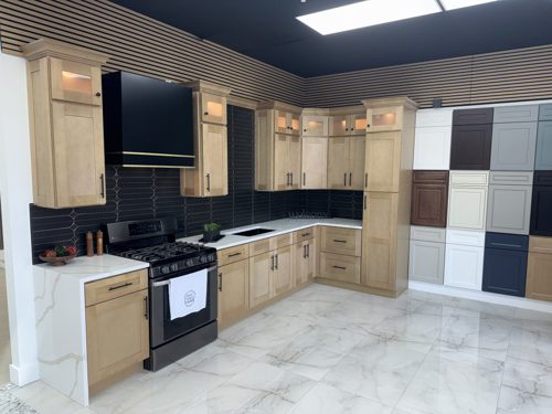 Natural maple cabinets with a black range hood and navy tile backsplash
