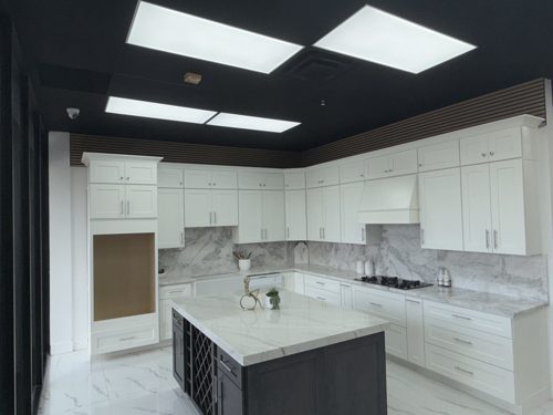 White shaker kitchen with a marble backsplash and a grey island