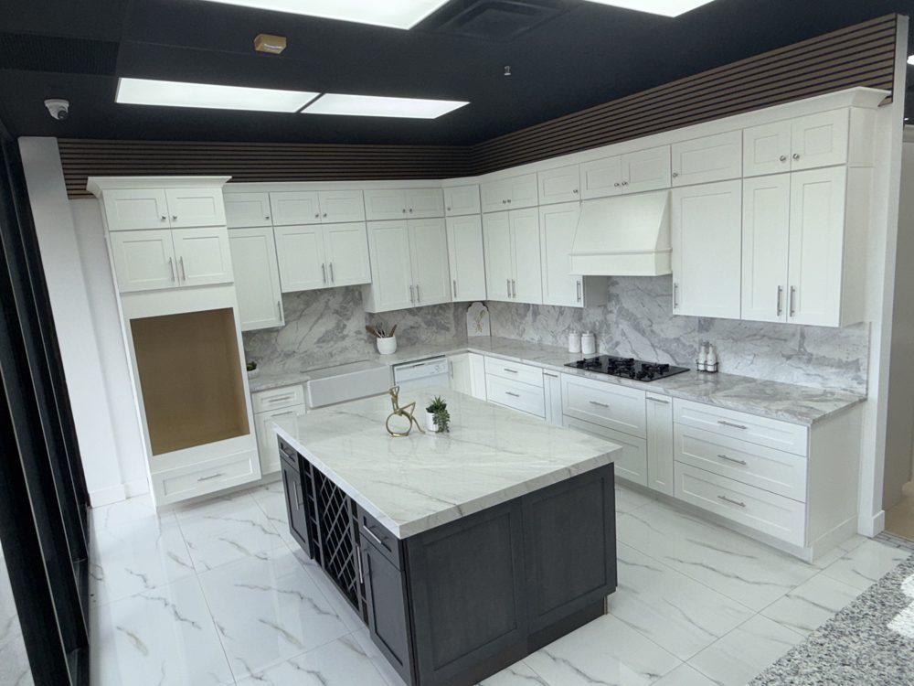 White shaker cabinets with marble backsplash and a grey island
